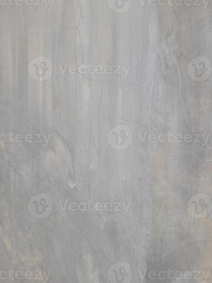 A plain gray textured surface with subtle irregular patterns and faint lines. The surface has a smooth yet natural appearance, resembling concrete or plaster with slight imperfections. photo