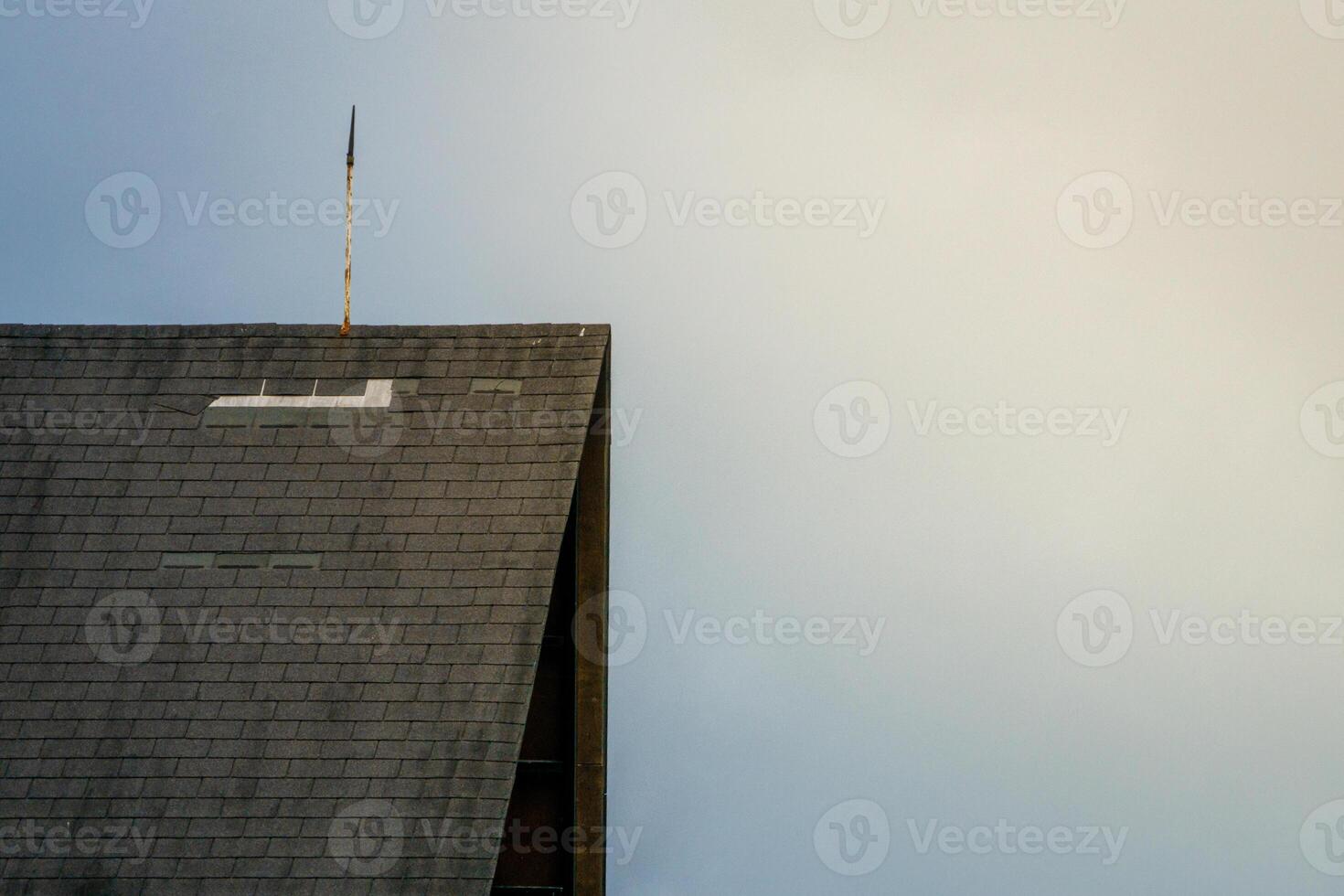 A view of a building with a roof, against a beautiful sky backdrop, showcasing architectural details and a clear, expansive horizon. Perfect for urban and architecture photography photo