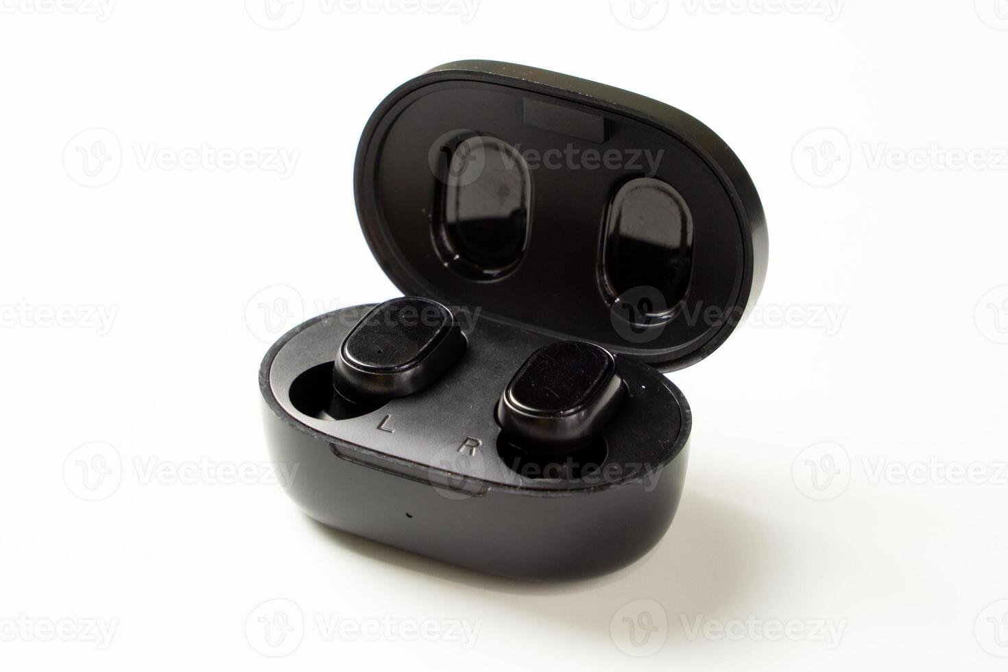 An isolated pair of black TWS or True Wireless Stereo earbuds placed on a flat surface, showcasing their sleek design and modern technology photo