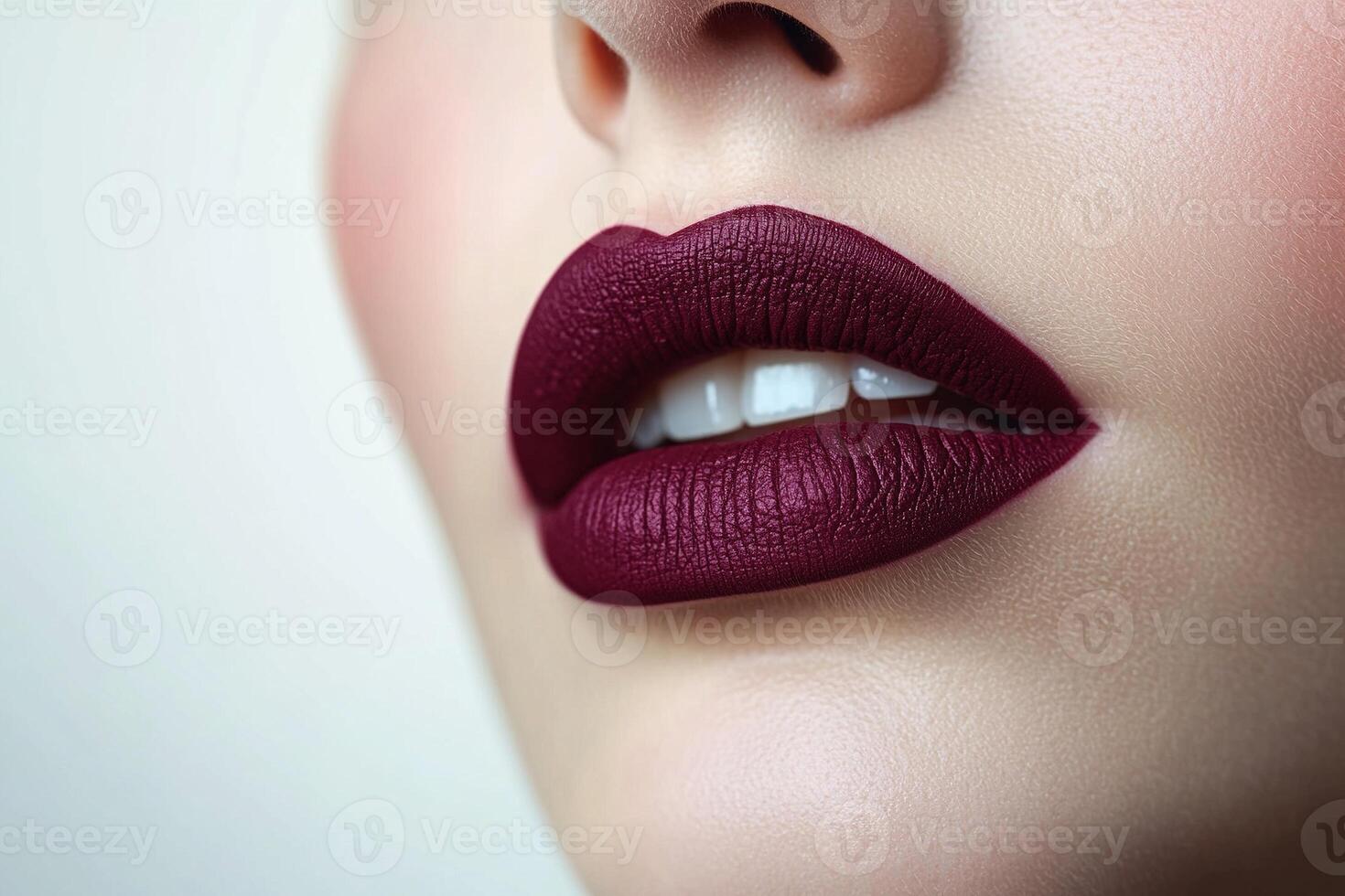 Close up of lips with rich plum matte lipstick capturing detailed texture and vibrant color photo