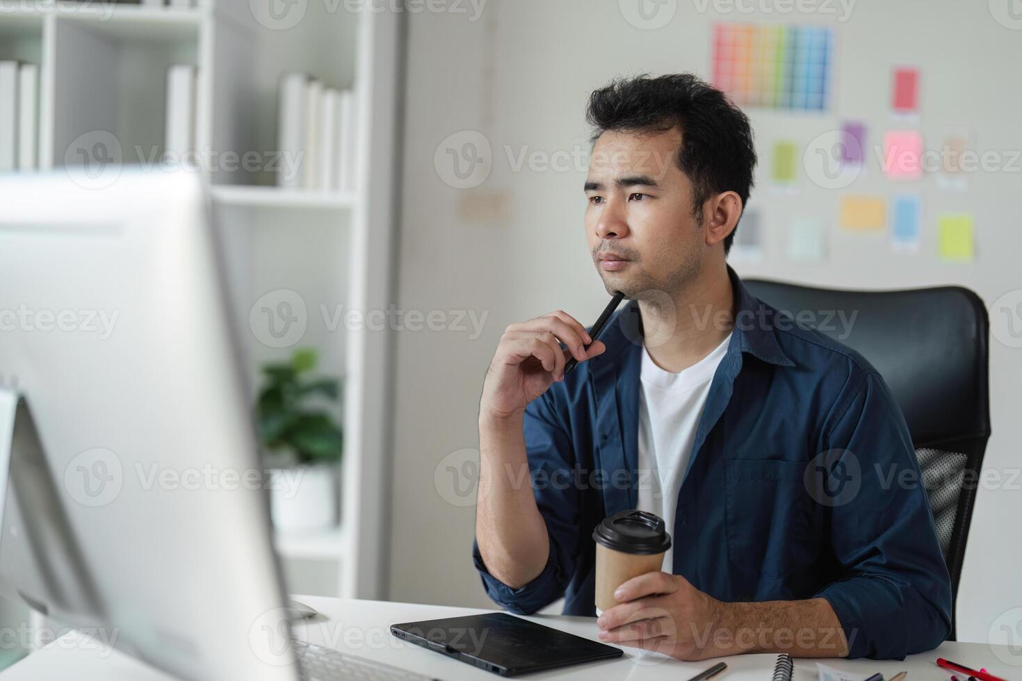 Focused Graphic Designer Strategizing a Creative Project in a Modern Office Environment with Digital Tools and Color Swatches photo