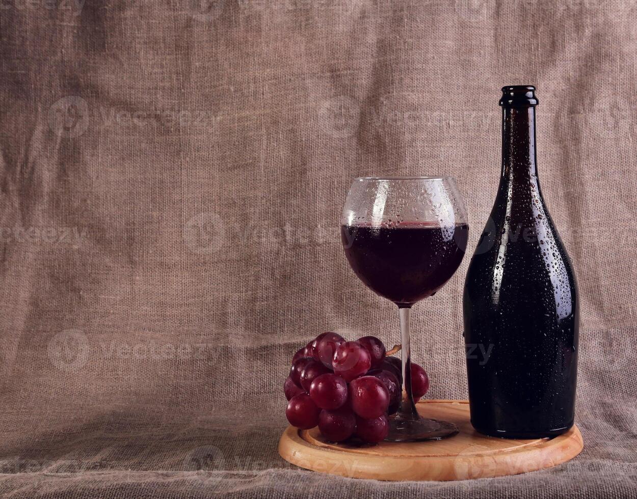 Red wine, cheeses and grapes in a still life setup. photo