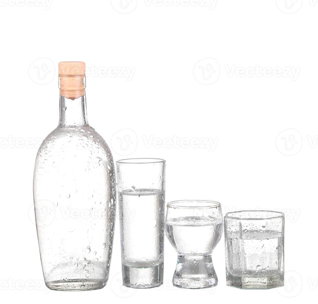 Bottle of vodka and wineglass isolated on white photo
