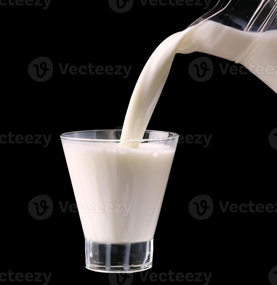 Splash in a glass with milk isolated on black photo