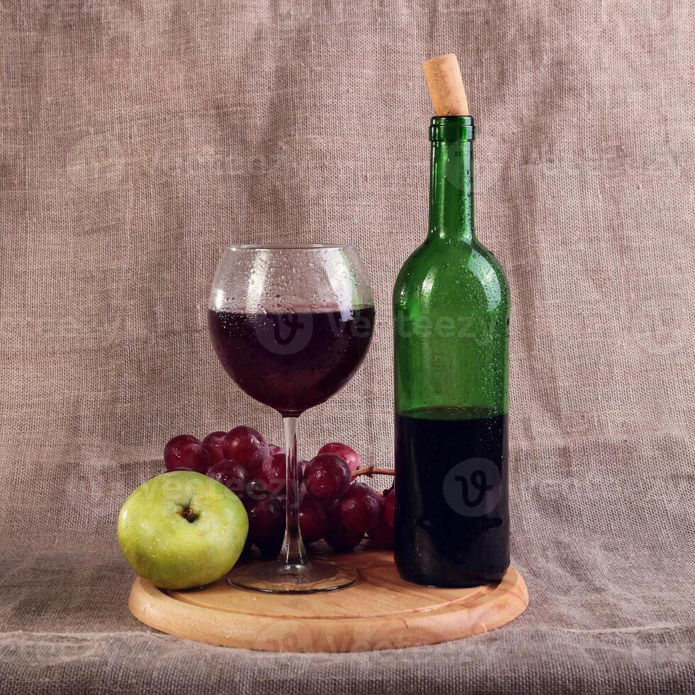 Red wine, cheeses and grapes in a still life setup. photo