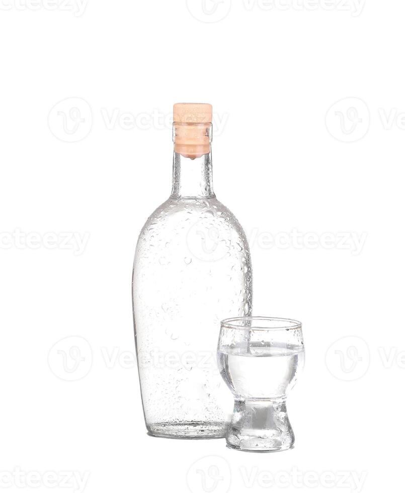 Bottle of vodka and wineglass isolated on white photo