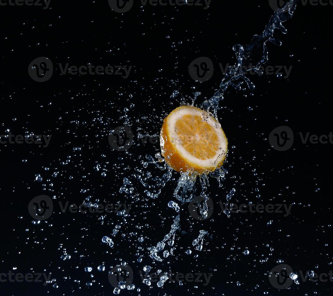 A high-speed shot of a lemon with splashing water, on a black background. photo