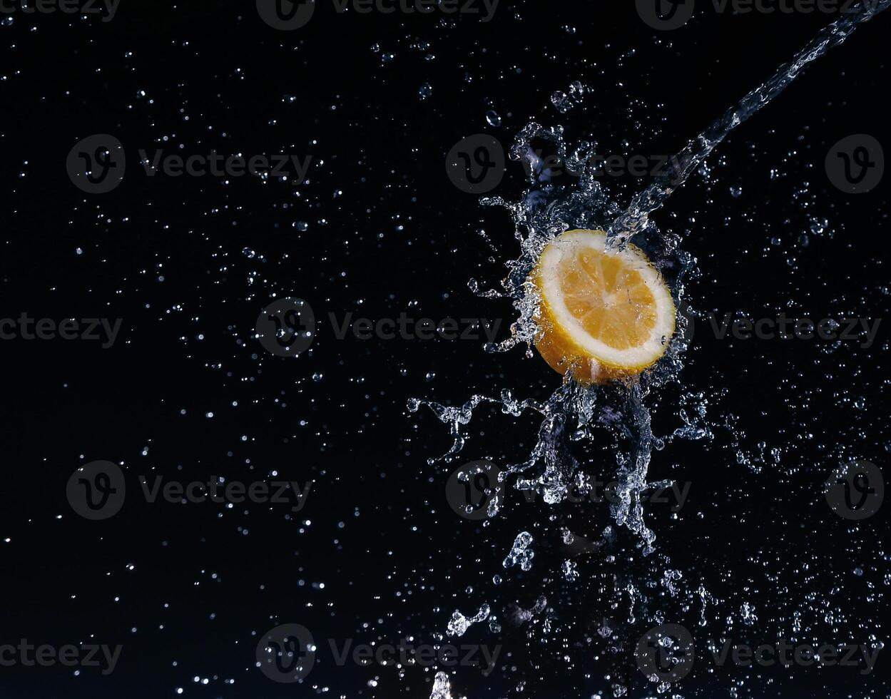 A high-speed shot of a lemon with splashing water, on a black background. photo