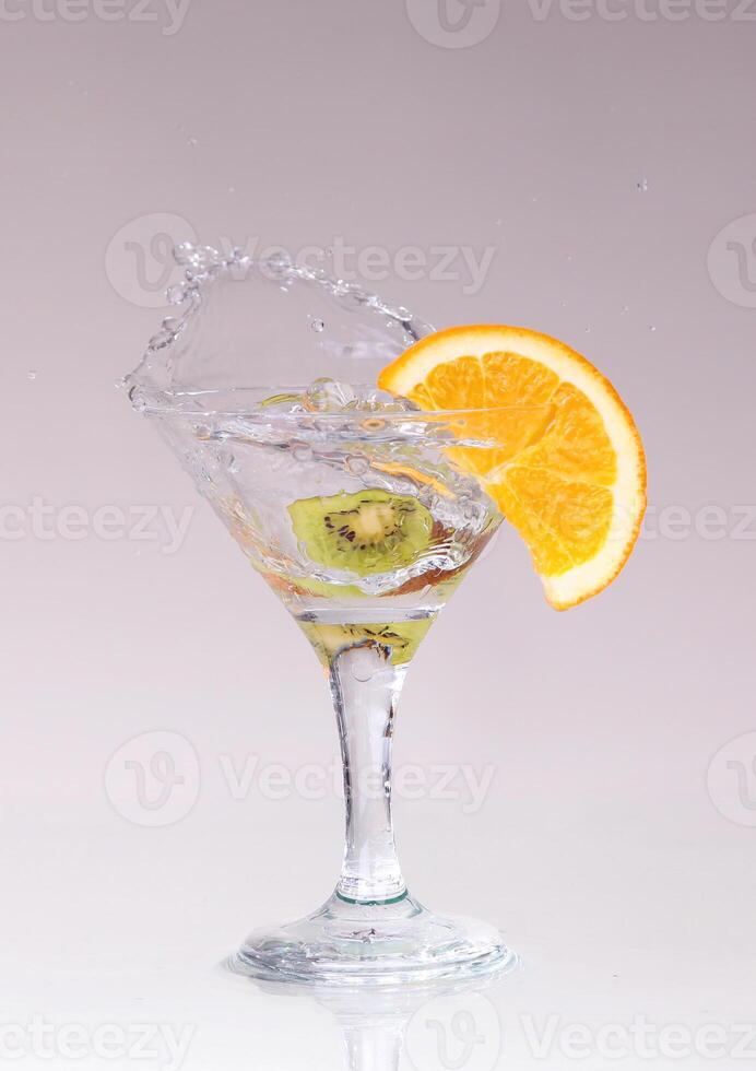 cocktail in a martini glass on a white background with fruit photo