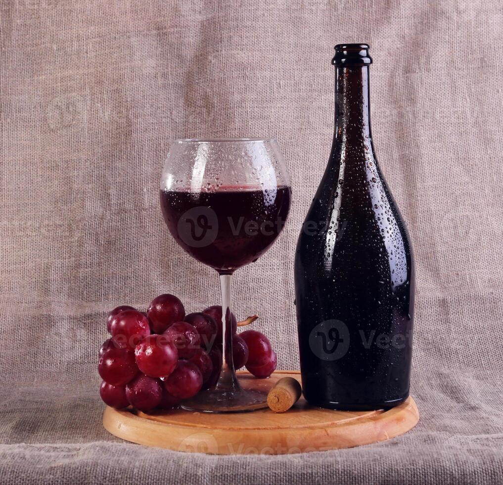 Red wine, cheeses and grapes in a still life setup. photo