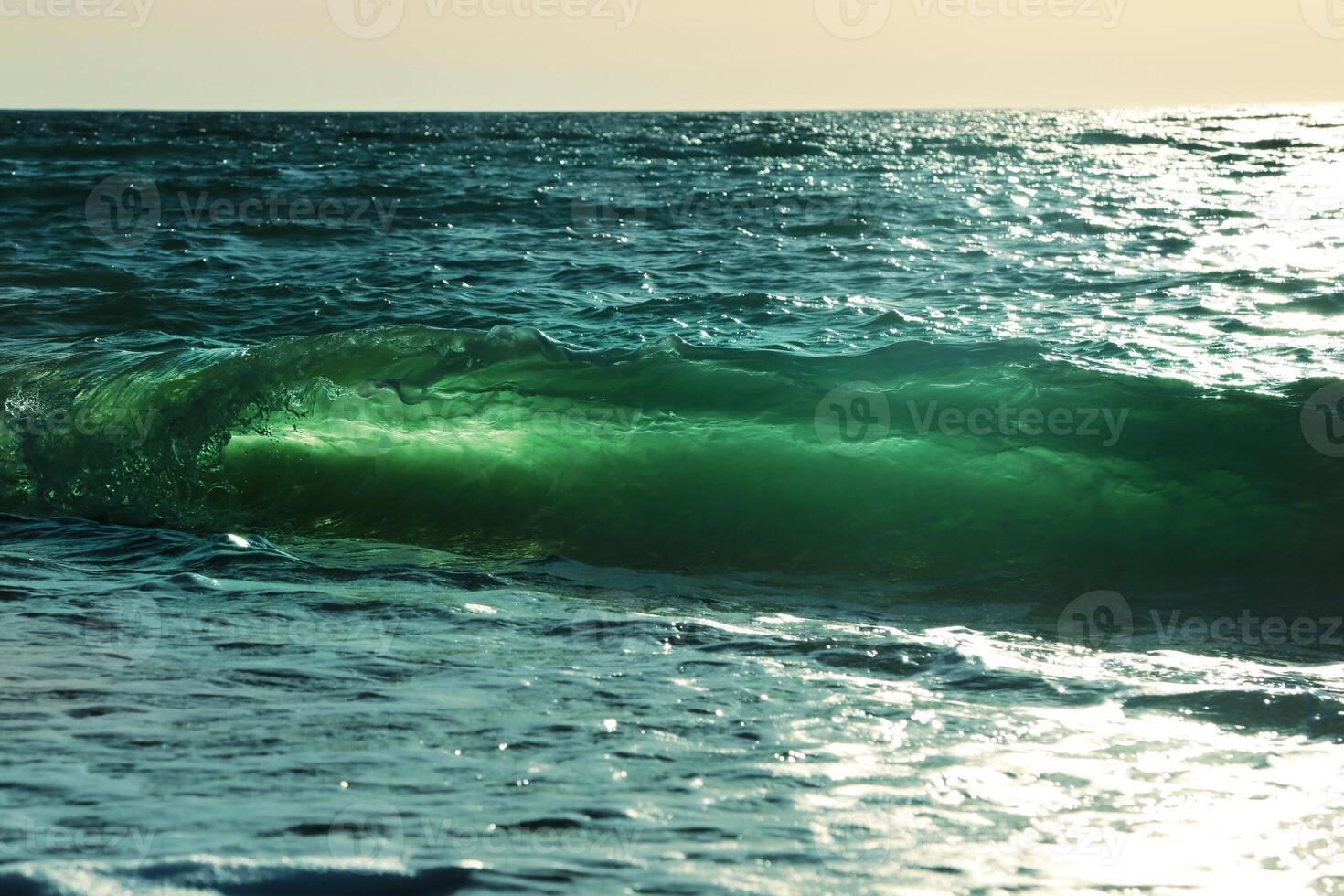Ocean-view design postcard. Beautiful colorful breaking surfing ocean wave rushing at sunset time photo