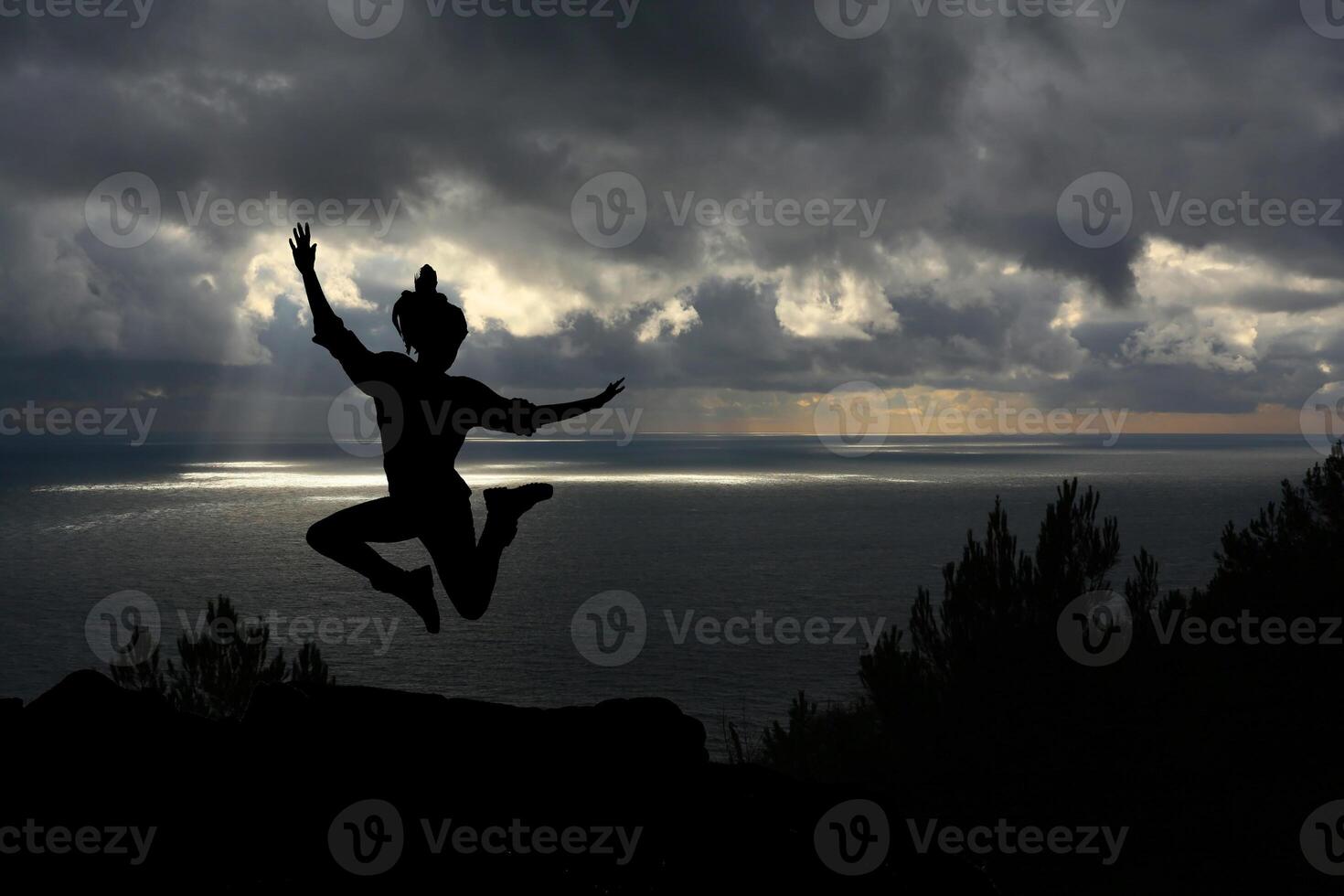 Happy woman jumping against beautiful sunset. Freedom, enjoyment concept. photo