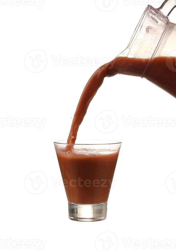 Pouring cocoa into a glass isolated over white background. Chocolate cocktail photo