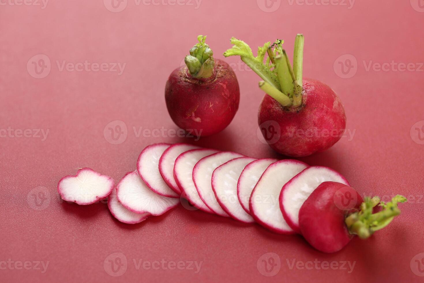 Sliced Red Radish on Red Background photo