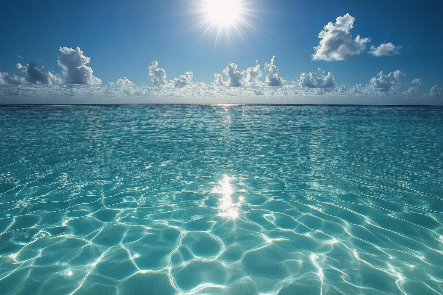 Serene turquoise ocean under bright sun reflects clouds and waves at midday by the coast photo