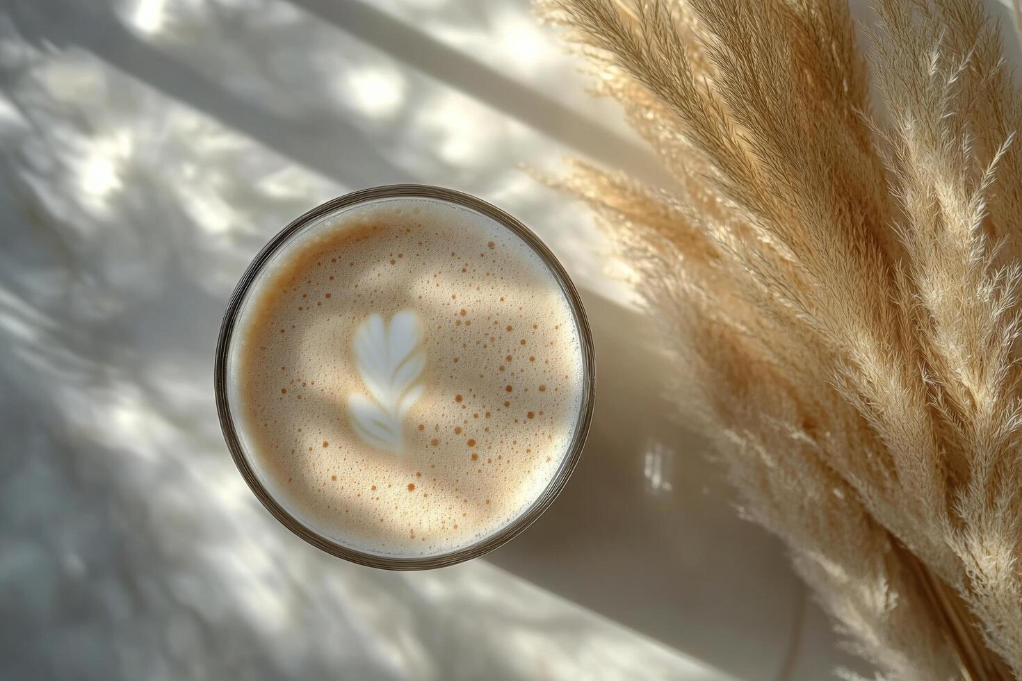 A cozy cup of cappuccino placed on a soft surface with dried grass in early morning light photo