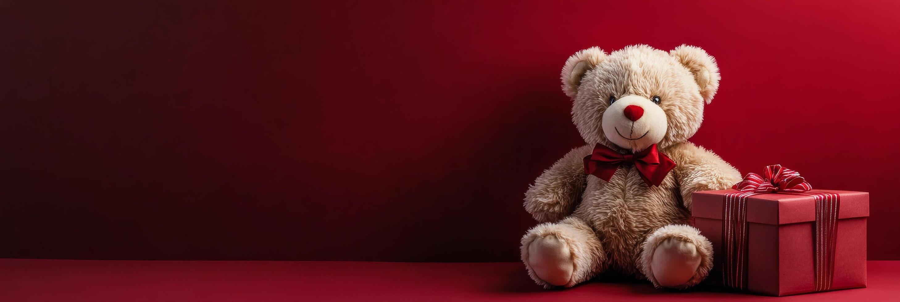 Soft bear beside a red gift box with a bow on a bright red background for festive occasions photo