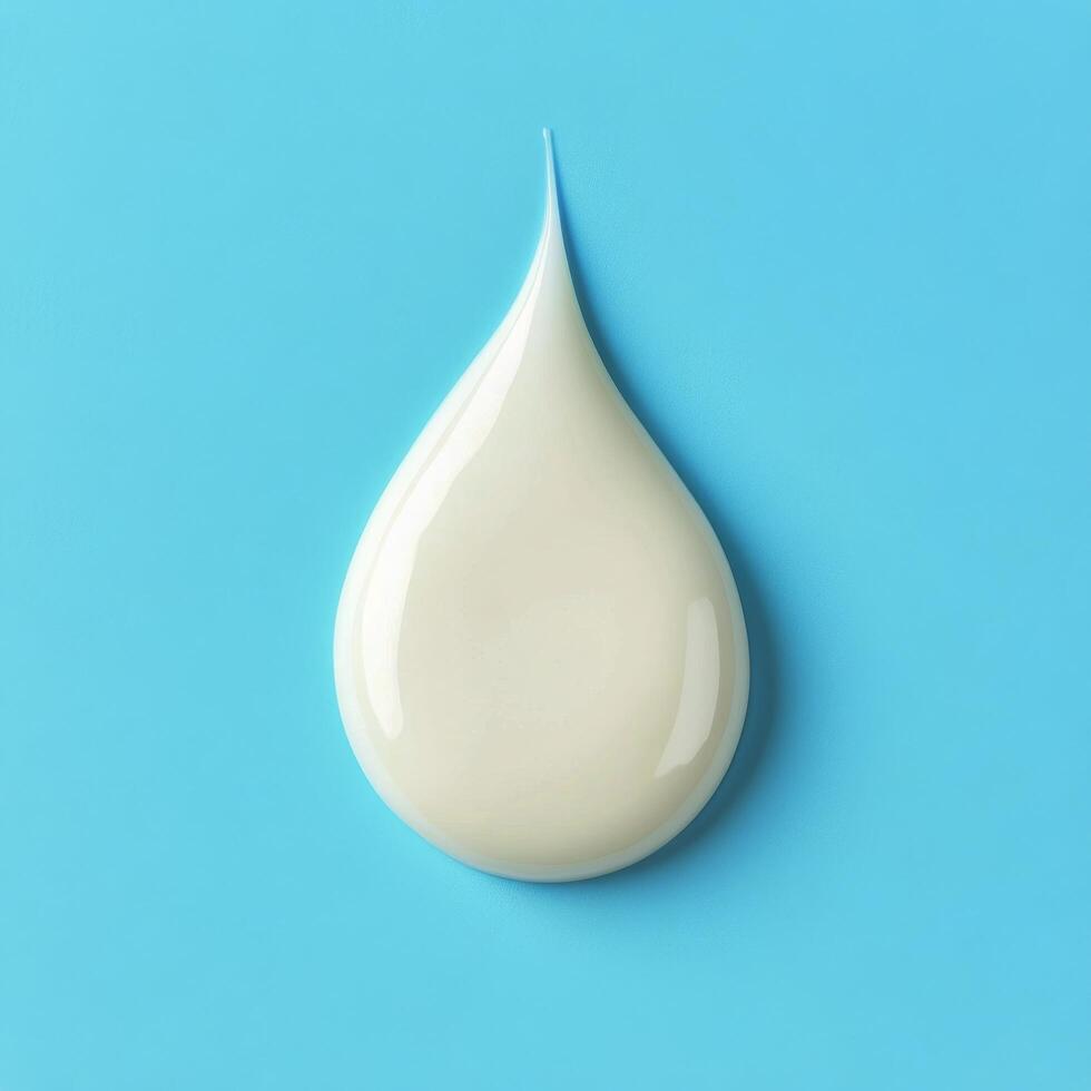 Droplet of cream on a light blue background demonstrating texture and color contrast photo