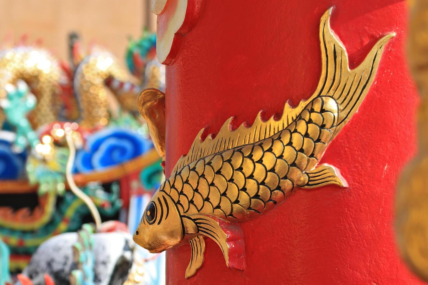 Cement carvings of fish are attached to the trunks of the pillars in the shrine. photo