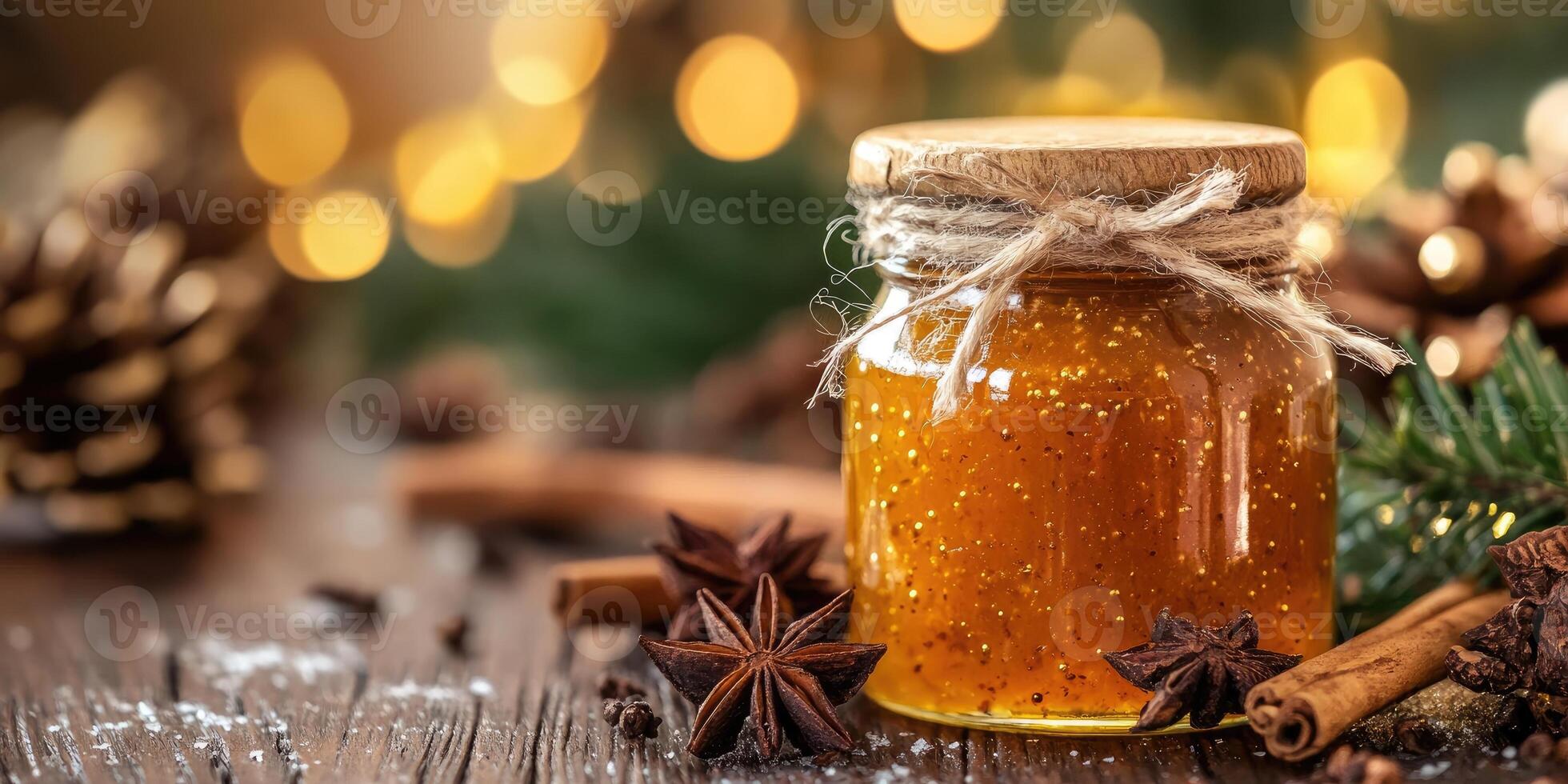 Orange jam jar with spices, pine cone and christmas lights creating festive atmosphere photo