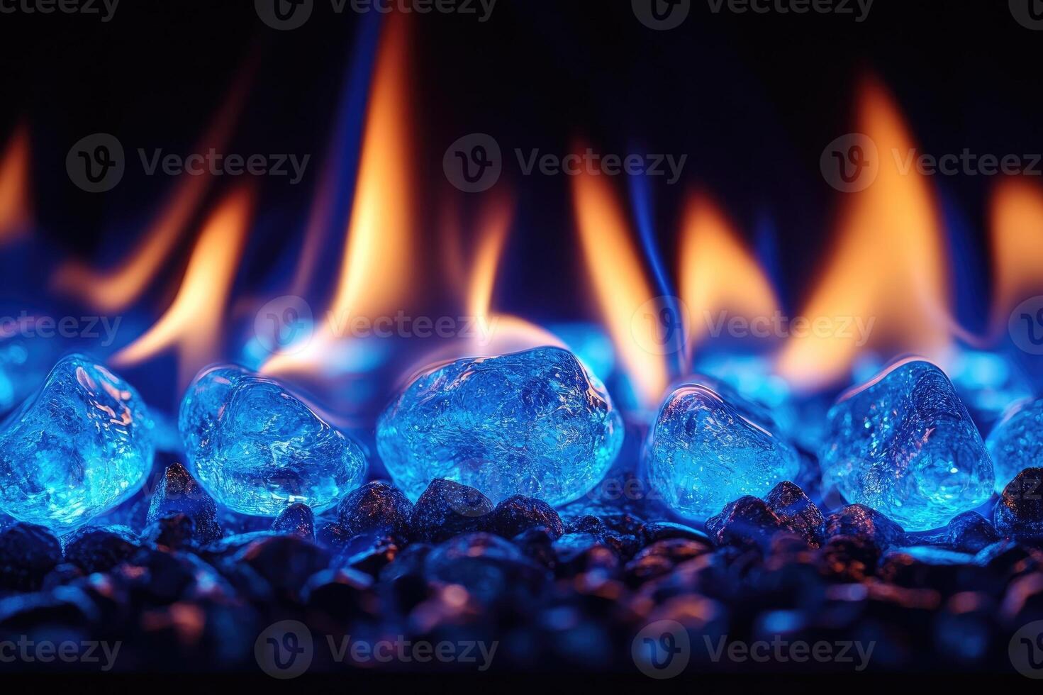 Vibrant flames heating glowing blue crystals on black pebbles photo