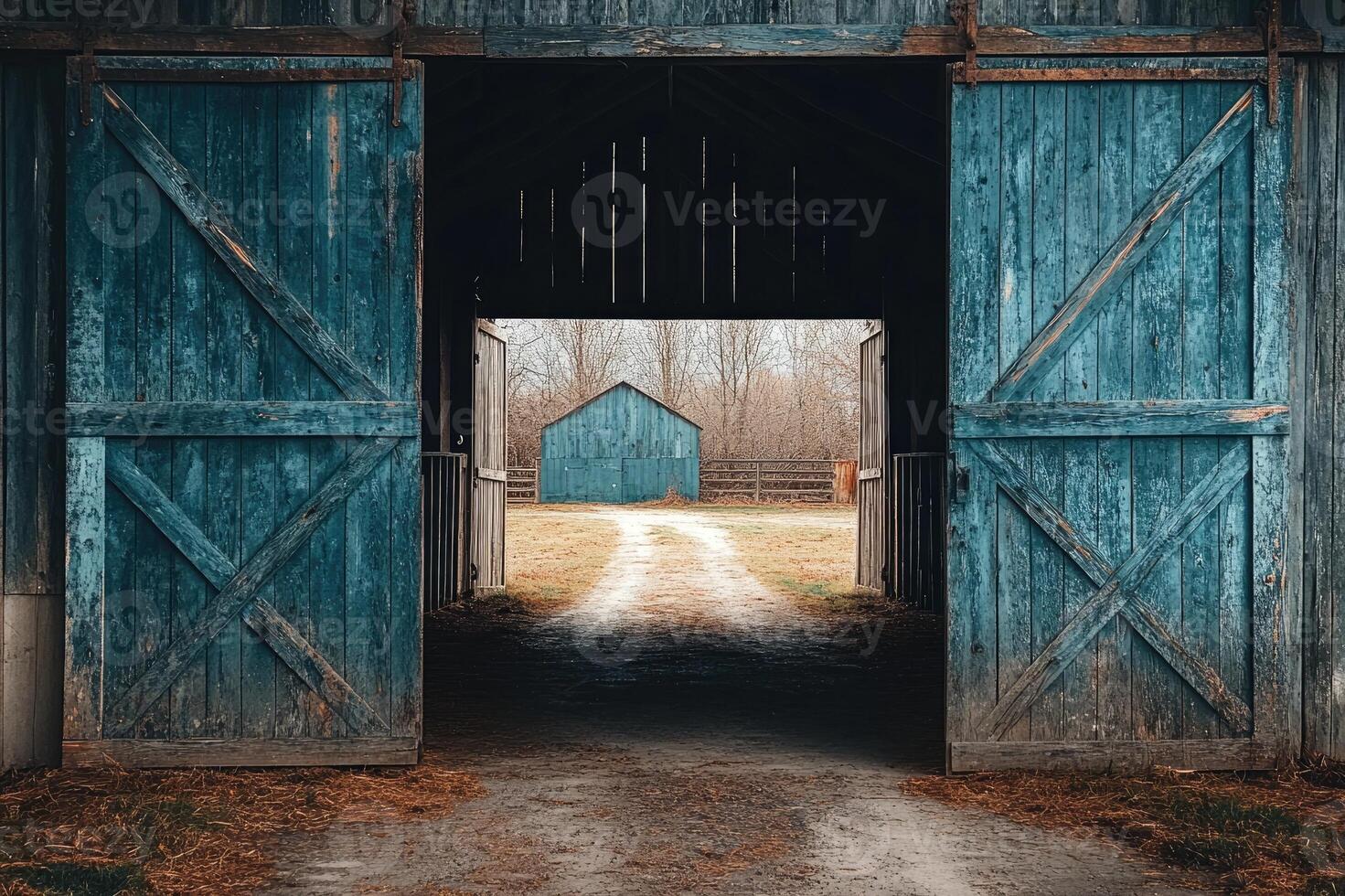 Open barn doors showing another barn and farmland beyond photo