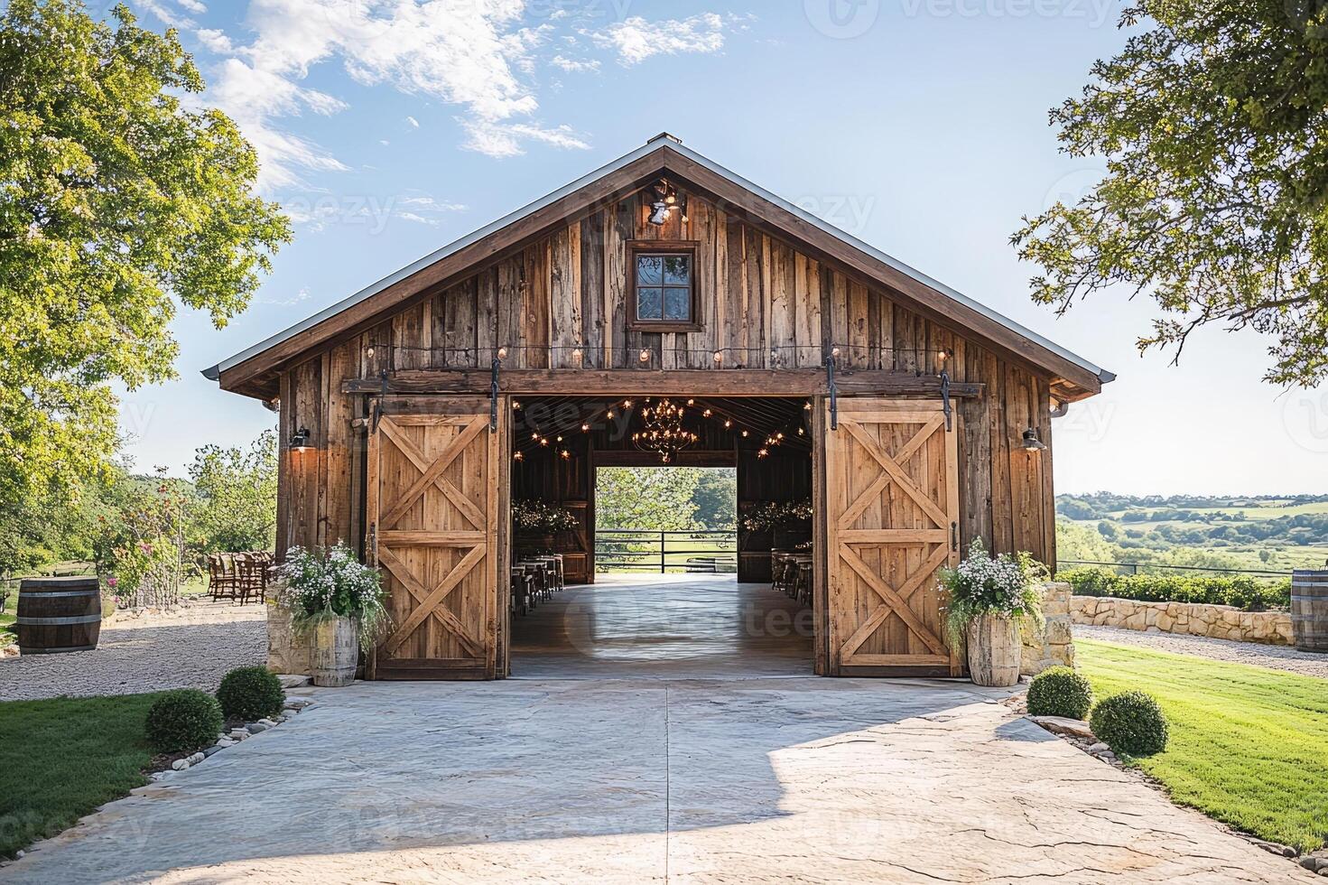 Rustic barn wedding venue showing rolling hills scenery with open doors and string lights photo