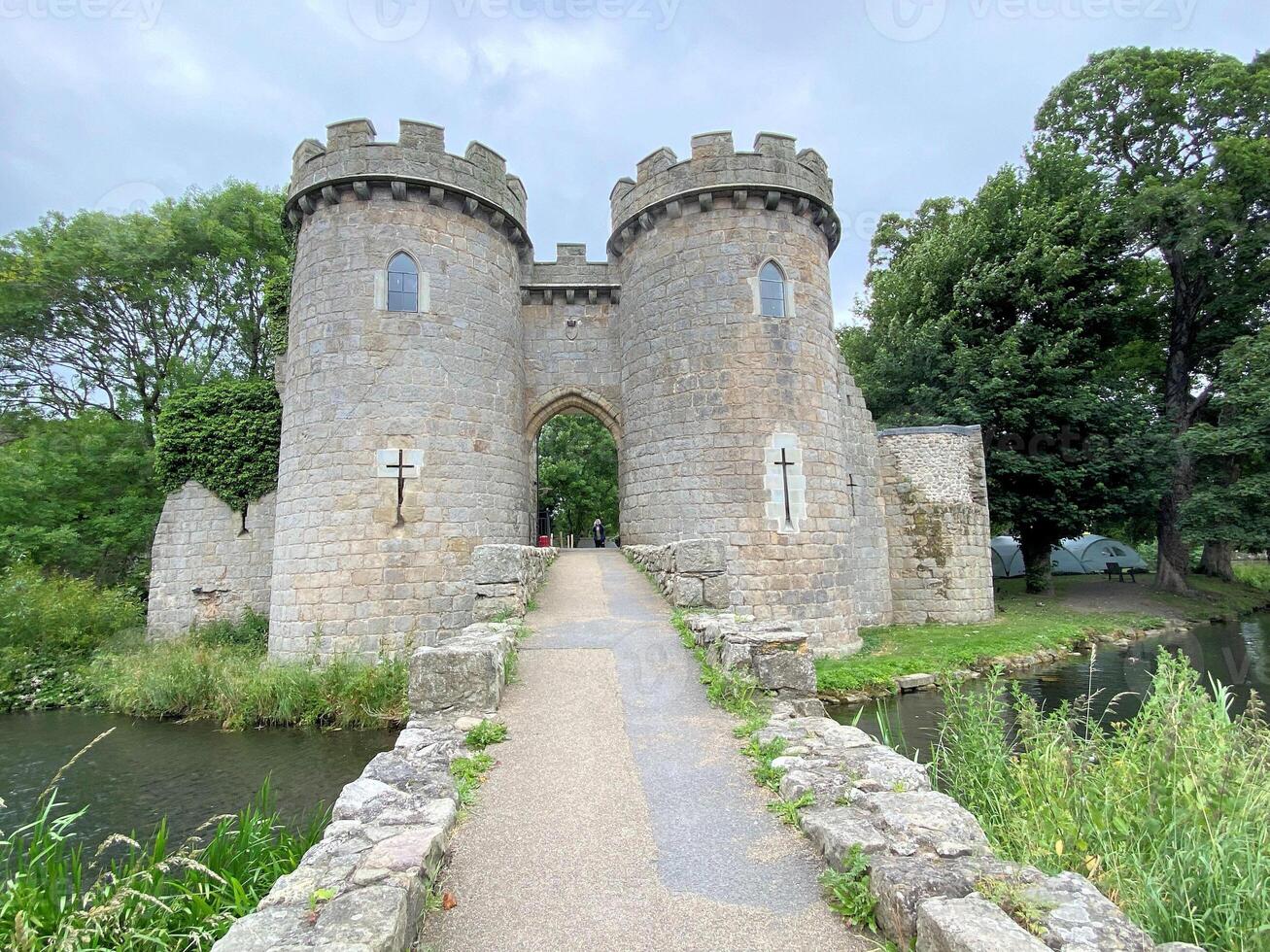 A stone castle with a bridge over a river photo