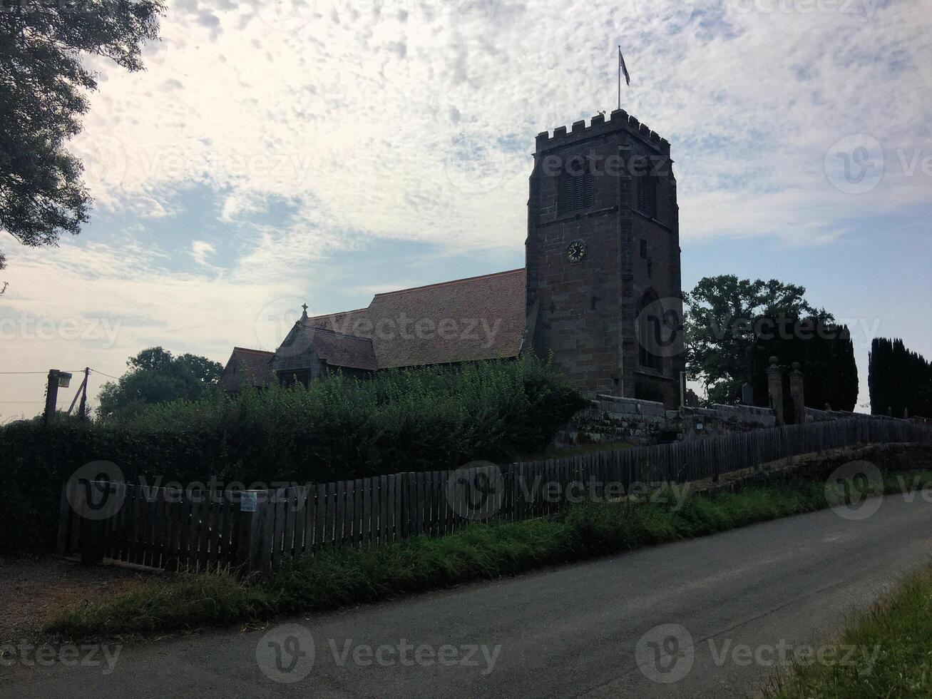A church with a steeple and a fence photo