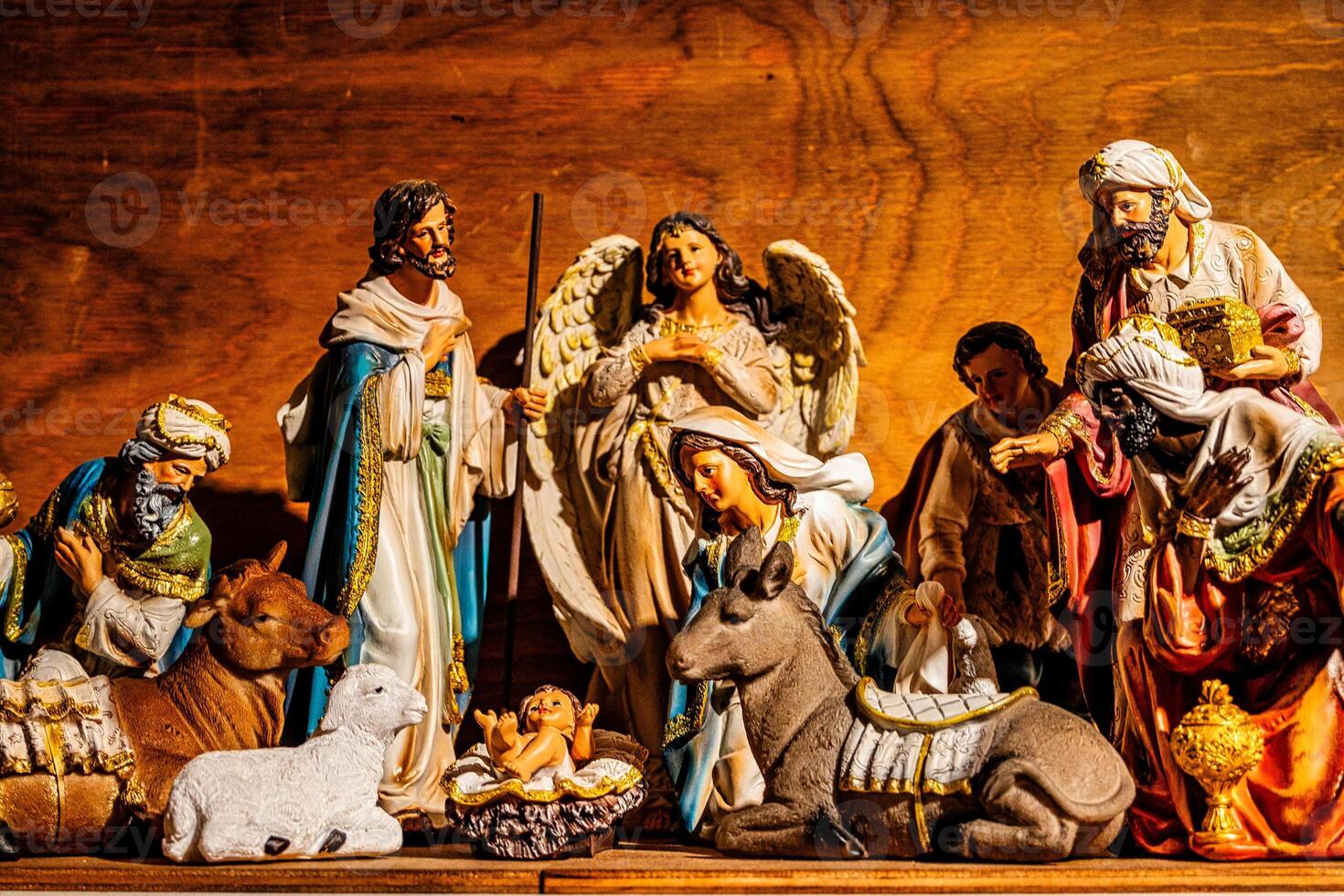 A detailed nativity scene showcases a collection of figures, including shepherds, angels, and the three Magi, gathered around baby Jesus in a manger photo