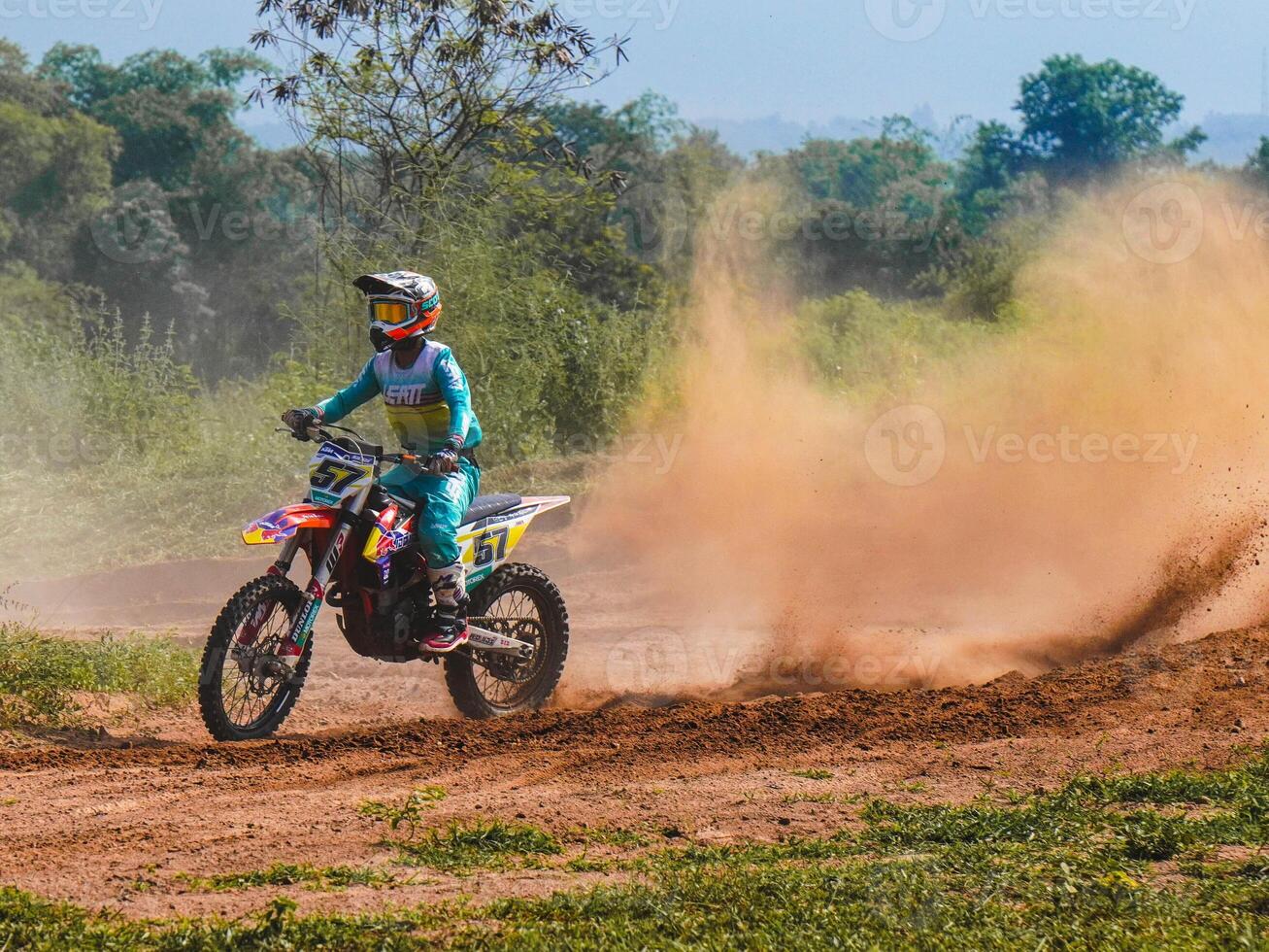 A biker creates a large cloud of dust and debris, Motocross concept photo