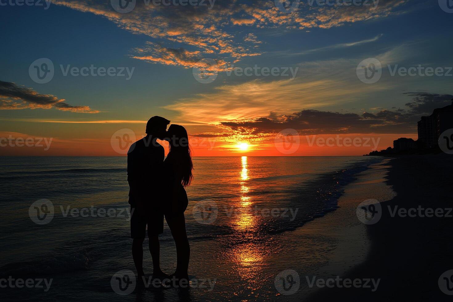 Perfect scene for Valentines Day with the silhouette of kissing on the beach with beautiful sunset in background. photo