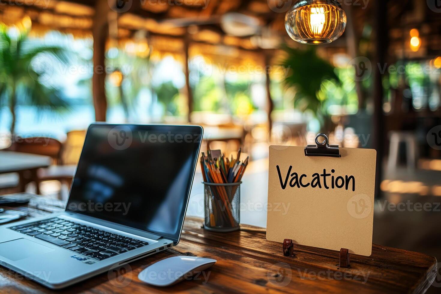 Office table with the message Vacation or holidays written on a note. Laptop and office supplies on blurred background. Out of the office. photo