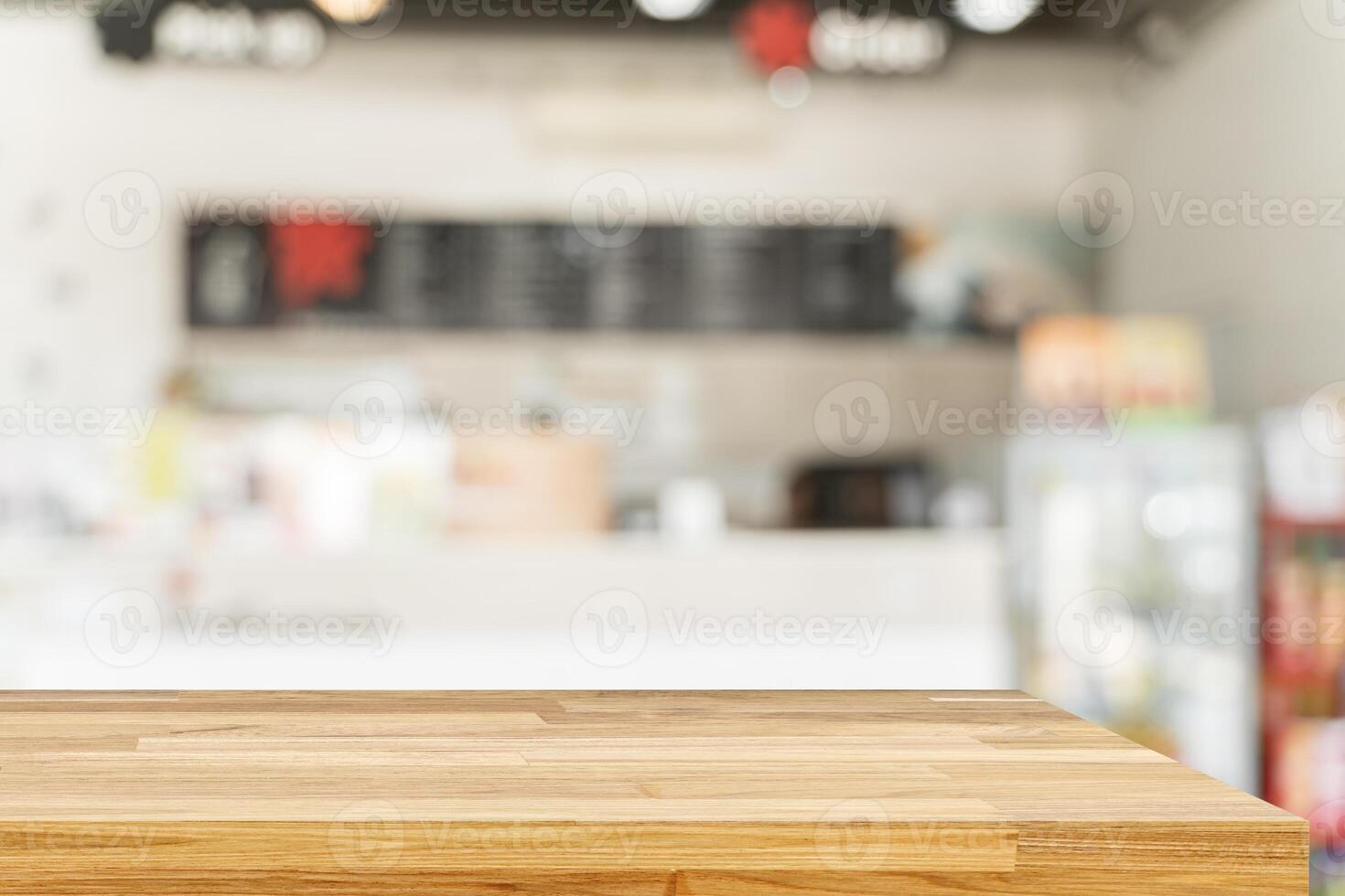 Wooden board empty table in front of blurred background. Brown wood over blur in coffee shop photo
