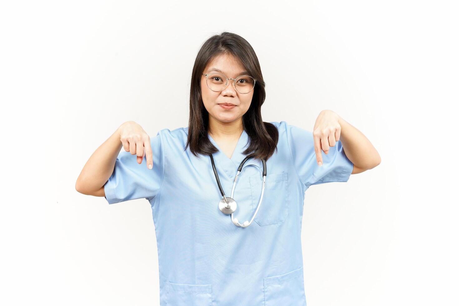 Showing Product and Pointing Down Of Asian Young Doctor Isolated On White Background photo