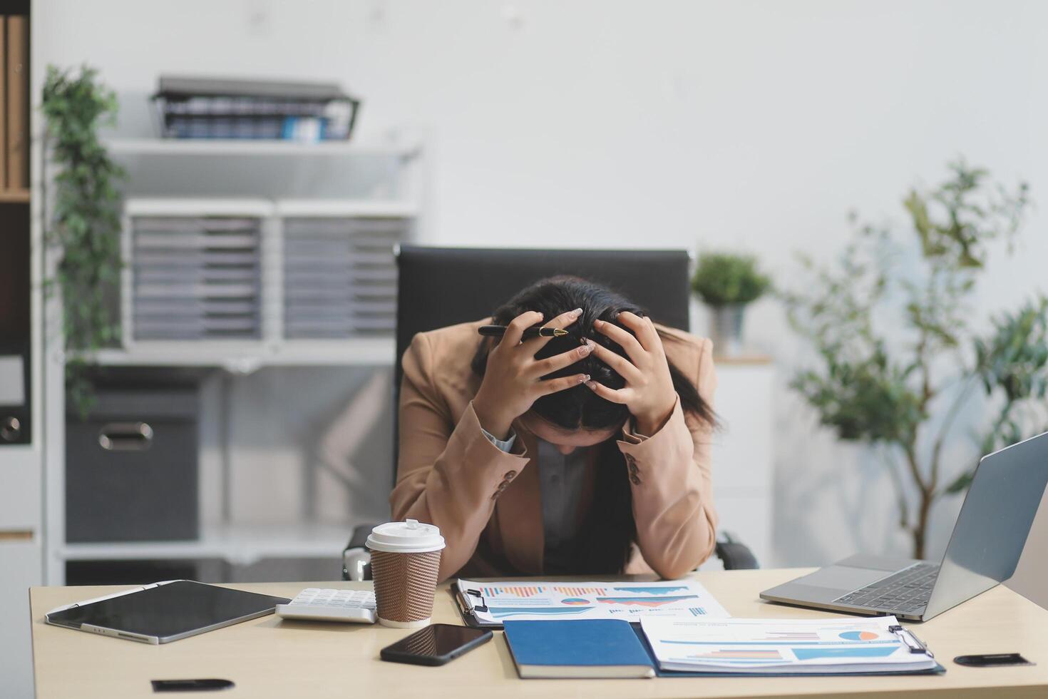 Portrait of tired young business Asian woman work with documents tax laptop computer in office. Sad, unhappy, Worried, Depression, or employee life stress concept photo