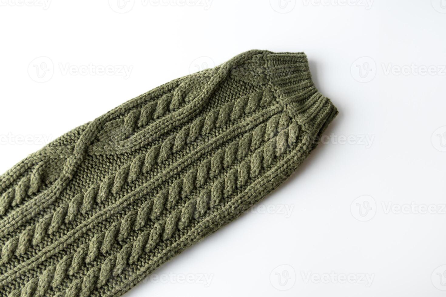 Sleeve with cuff of a warm green sweater. Knitted sweater is handmade from wool. braid knitting pattern photo