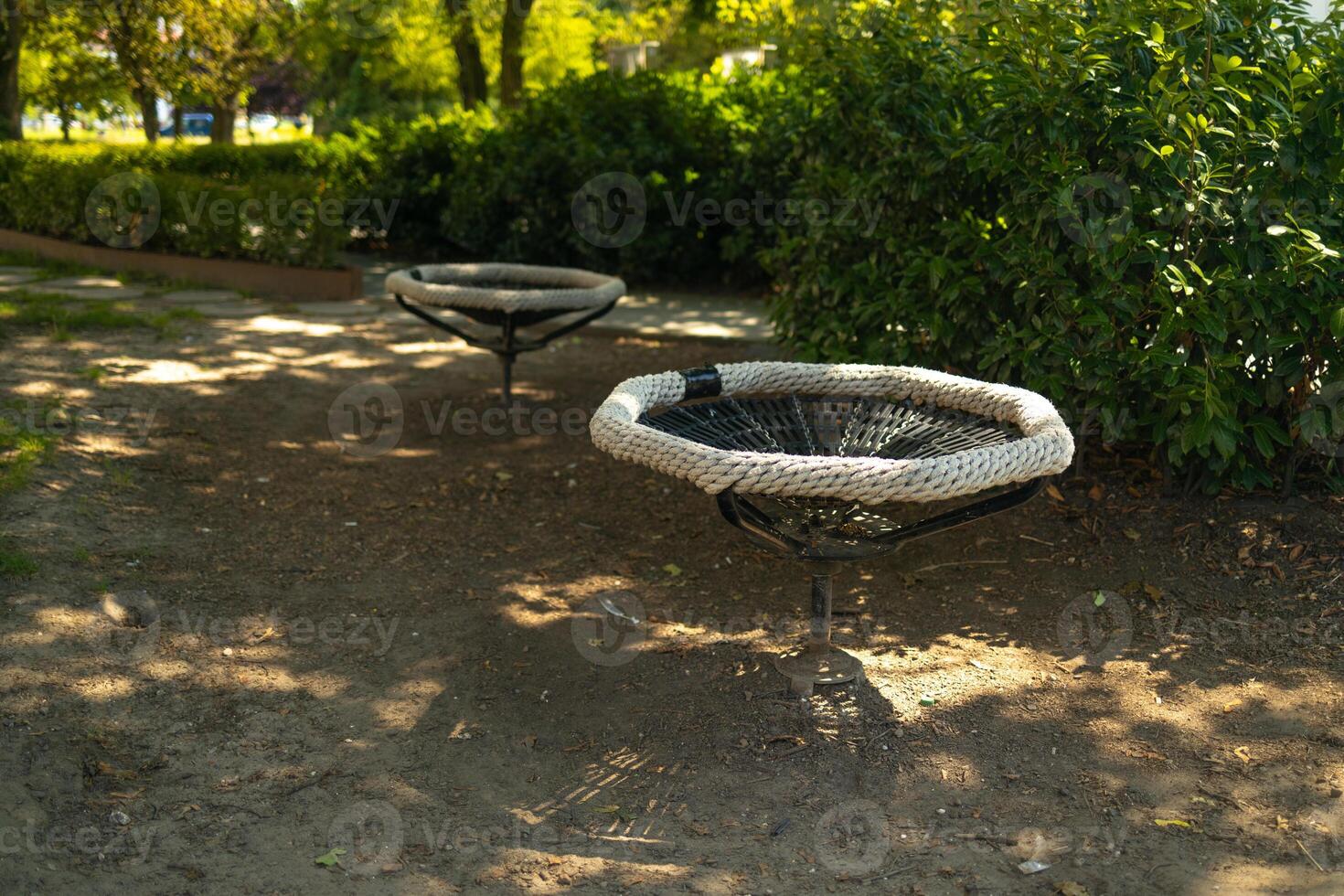 Black white rope circle swing seat at the playground close-up. Black net swing bench on a kids playground. Modern urban environment. photo