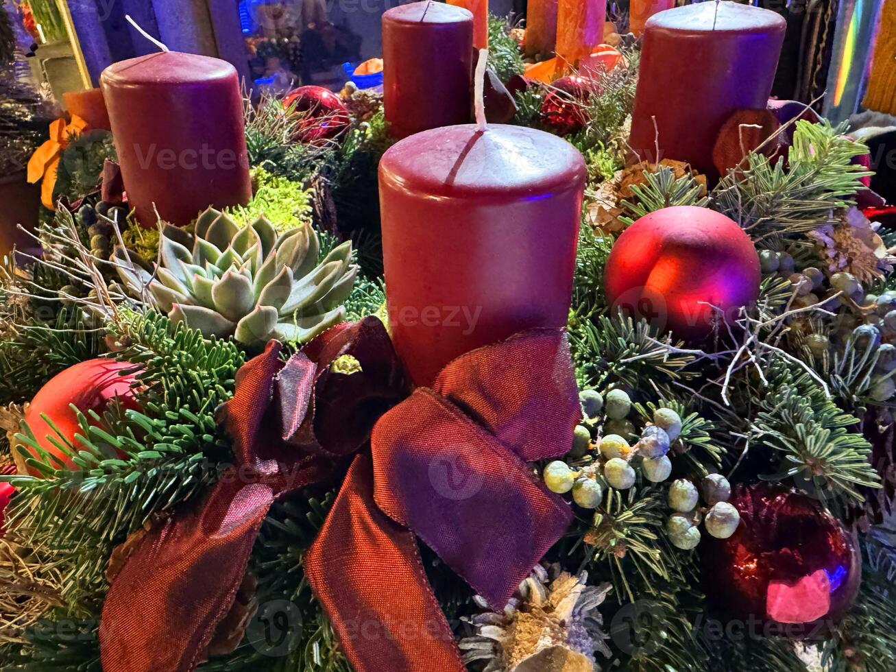 Festive christmas candle arrangement with red ornaments and pinecones photo
