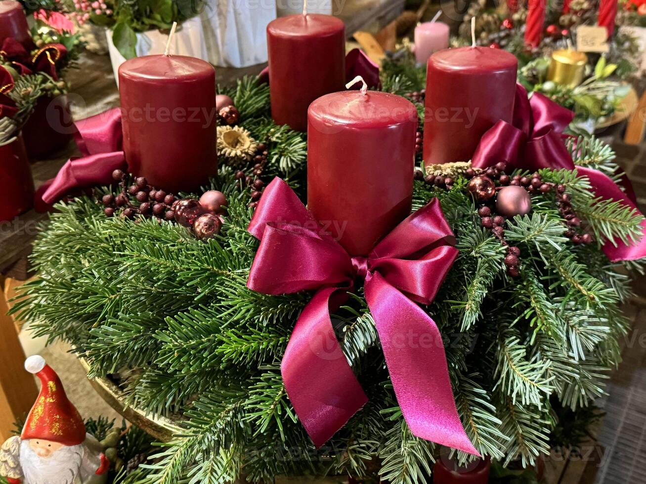Festive christmas wreath with red candles and ribbons on evergreen base photo