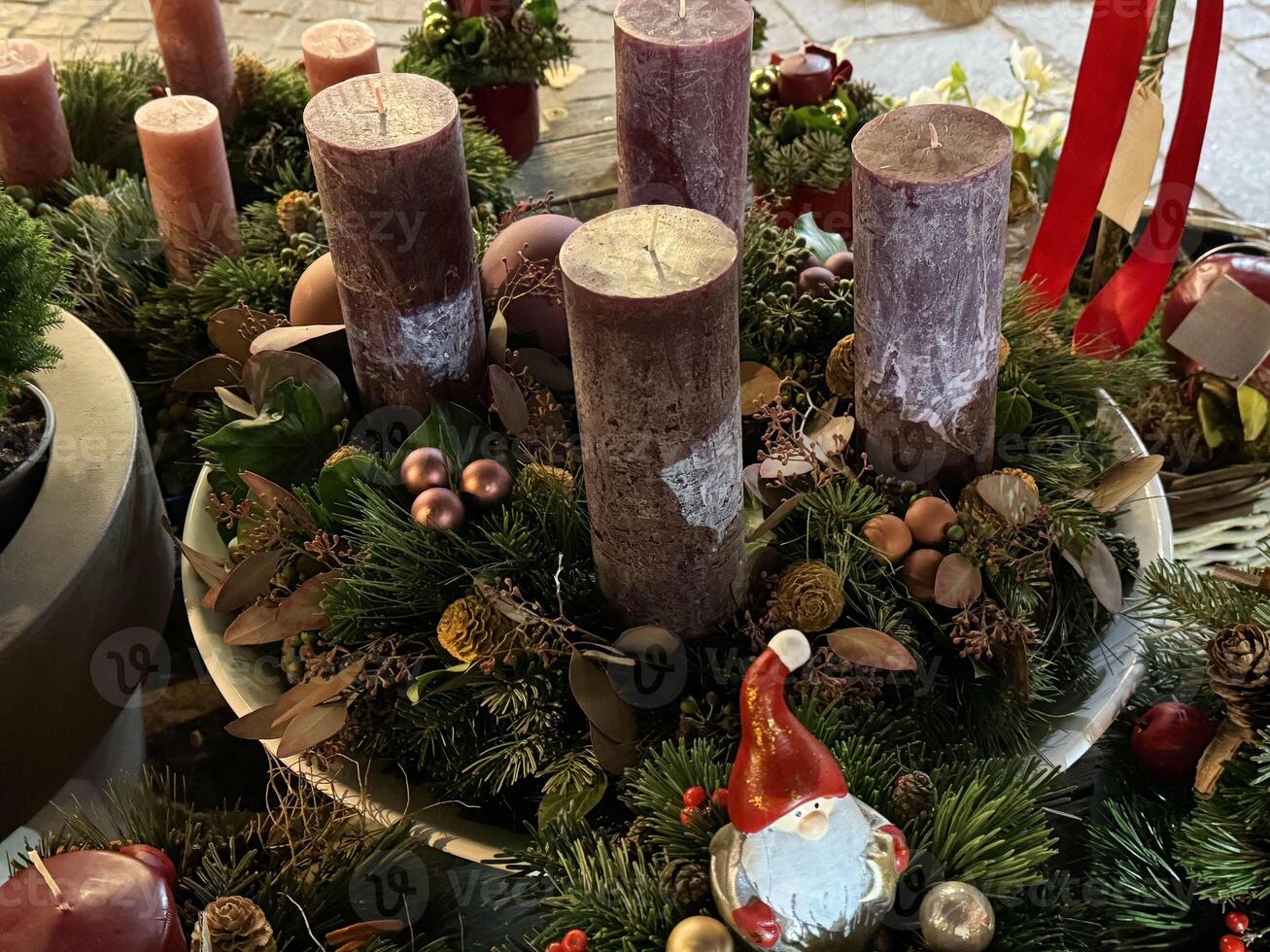 Festive christmas candle arrangement with santa figurine and greenery photo