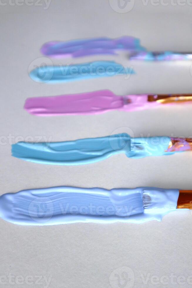 Brushstrokes of acrylic paints in pastel colors on the sheet. photo