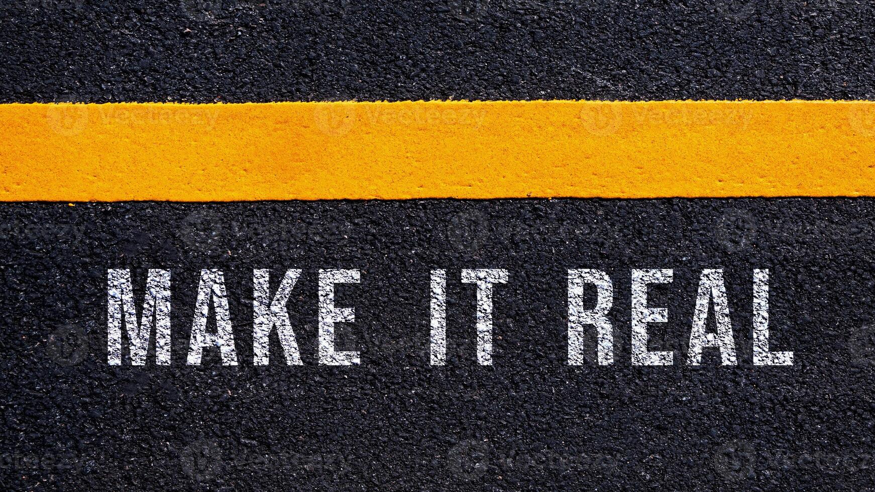 Make it real text written and yellow line on asphalt road ground, Business motivation and inspiration. photo