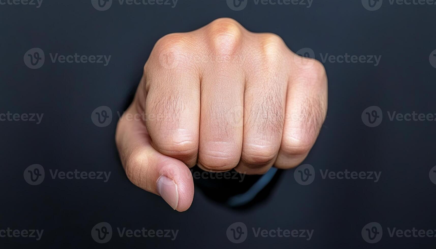 A clenched fist against a dark backdrop symbolizes strength and determination photo