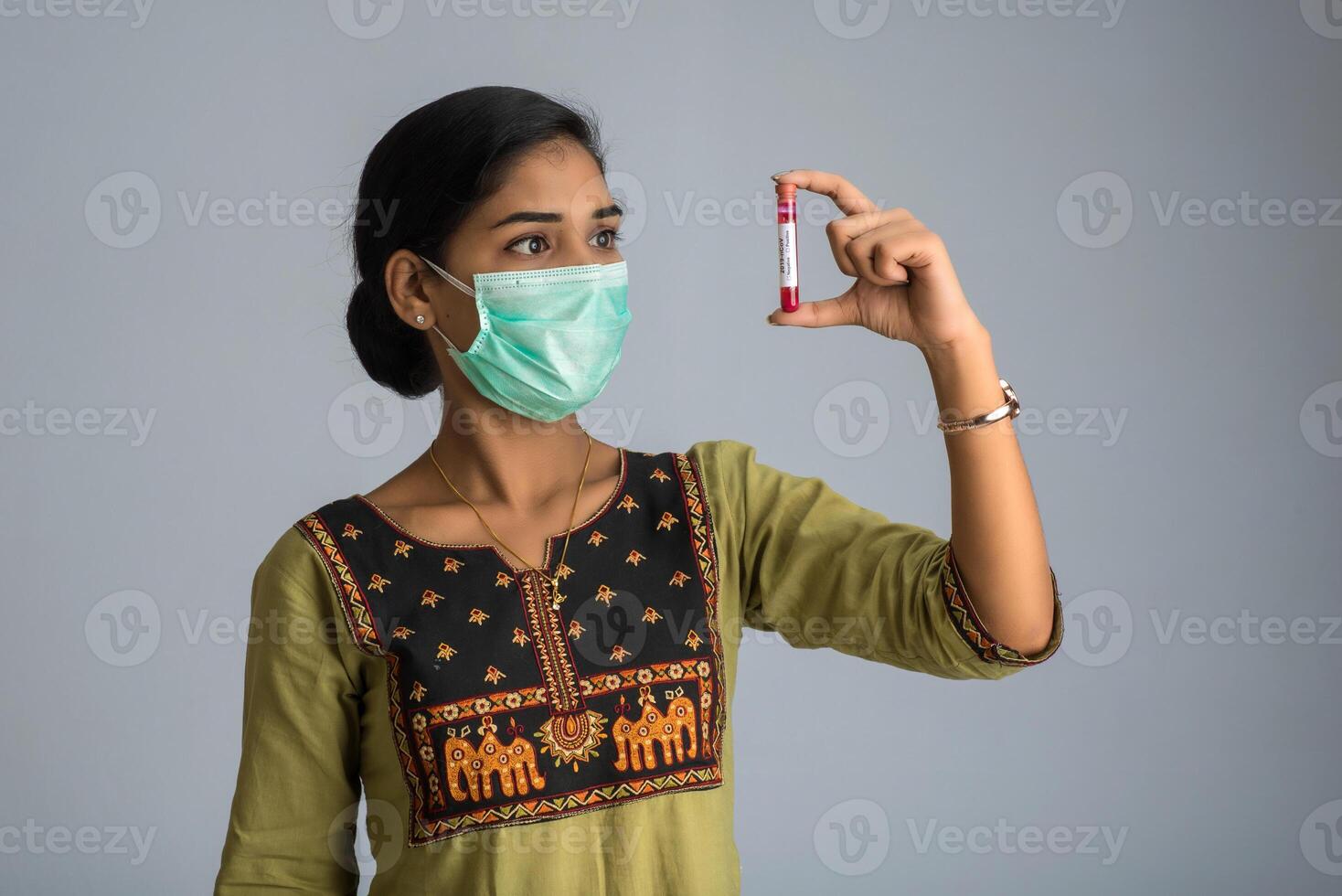 Woman holding a test tube with blood sample for coronavirus or 2019-nCoV analyzing. photo