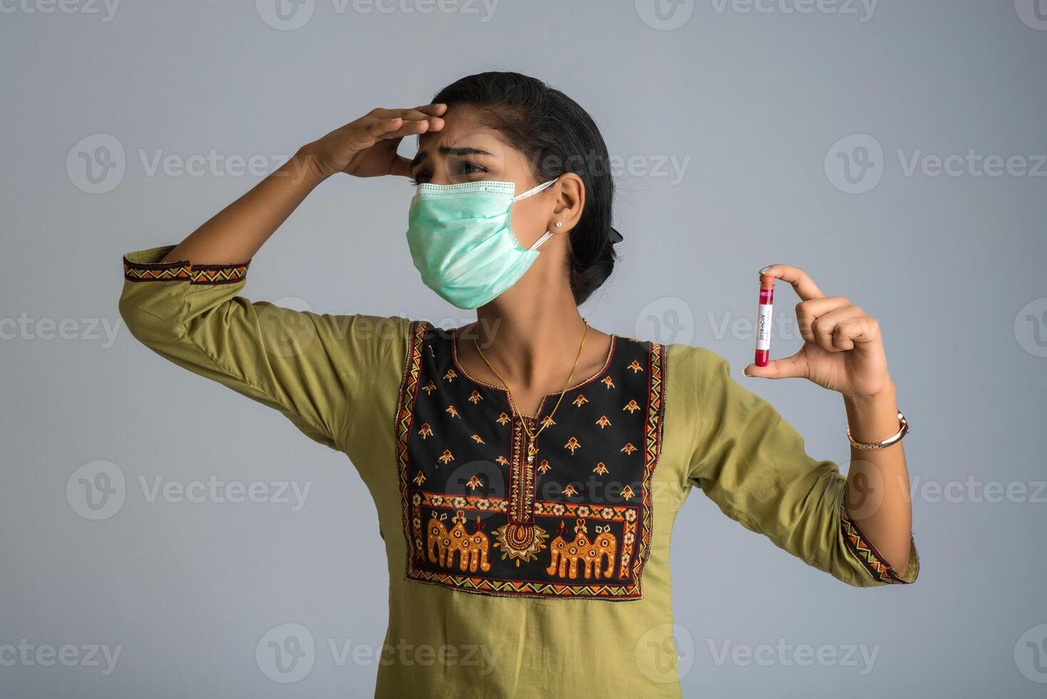 Woman holding a test tube with blood sample for coronavirus or 2019-nCoV analyzing. photo