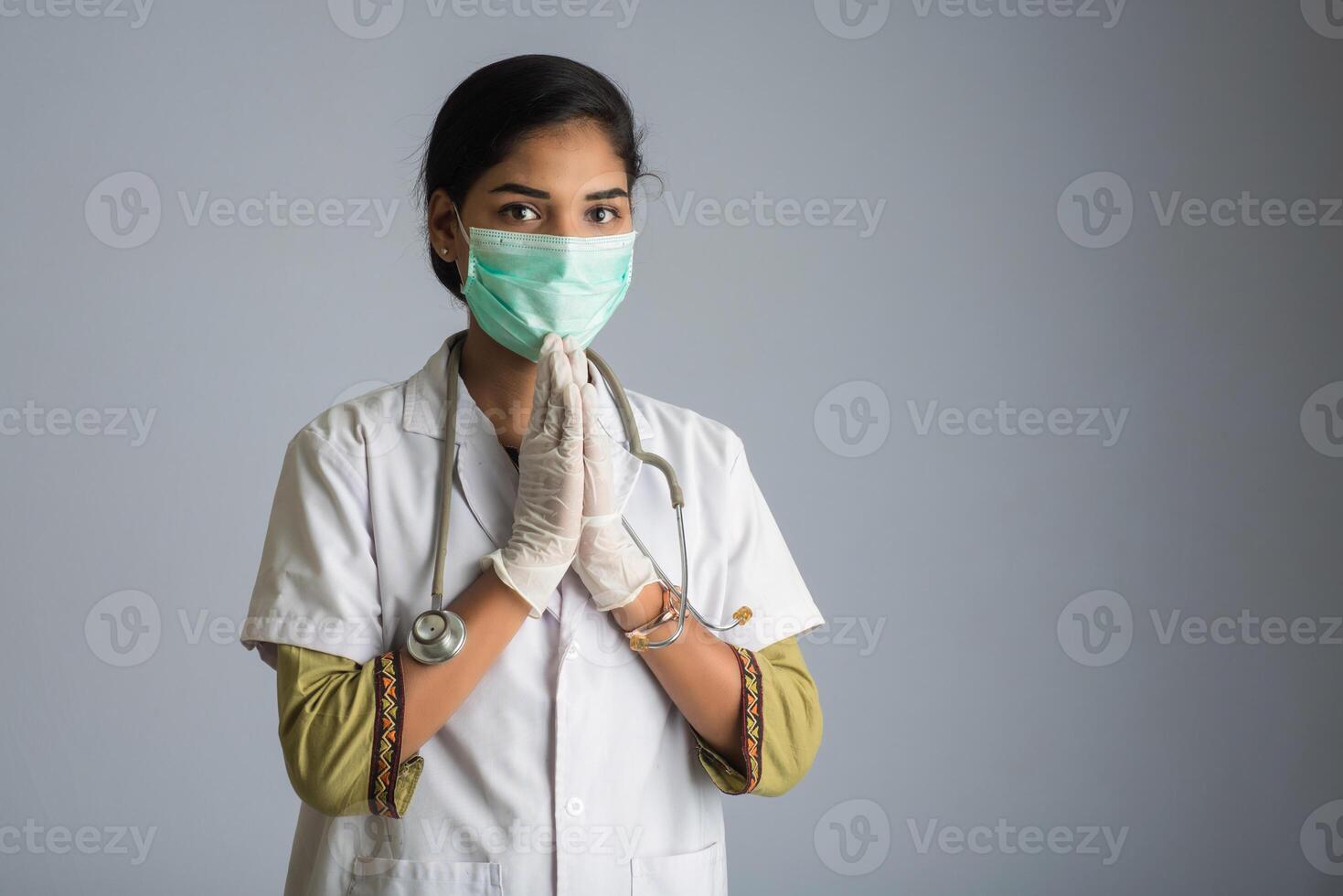 Young woman Doctor doing Namaste because of outbreak of COVID-19. New greeting to avoid the spread of coronavirus instead of greeting with a hug or handshake. photo
