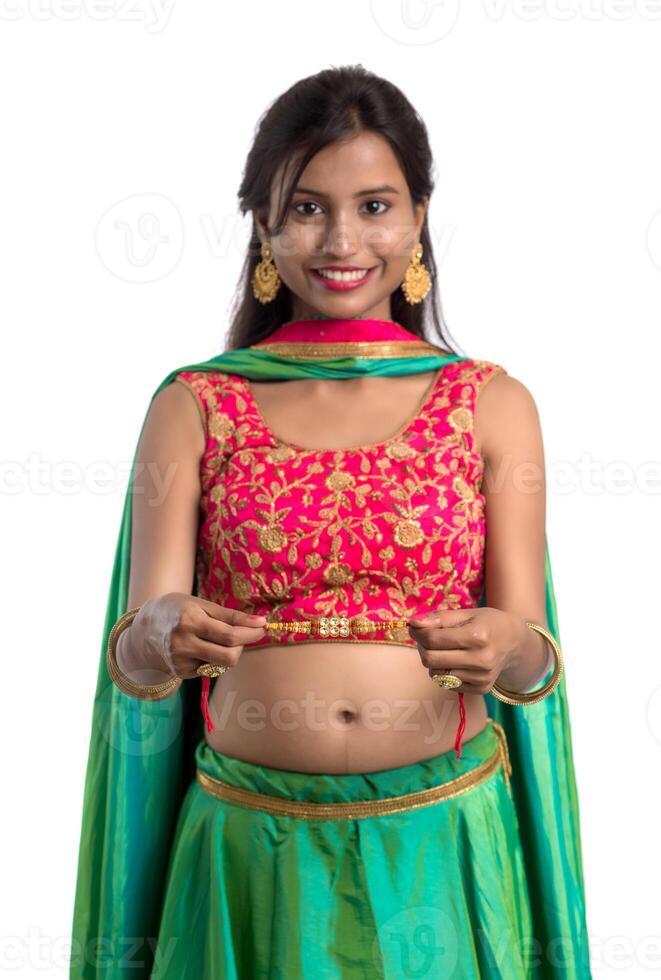 Beautiful girl showing Rakhi on occasion of Raksha bandhan on a white background. Sister tie Rakhi as symbol of intense love for her brother. photo