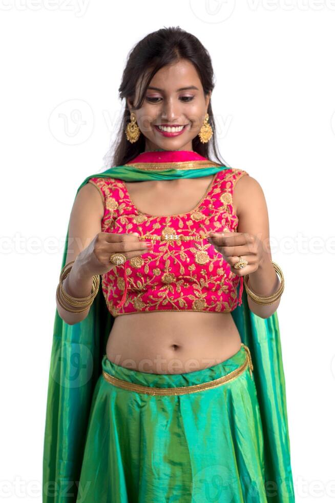 Beautiful girl showing Rakhi on occasion of Raksha bandhan on a white background. Sister tie Rakhi as symbol of intense love for her brother. photo