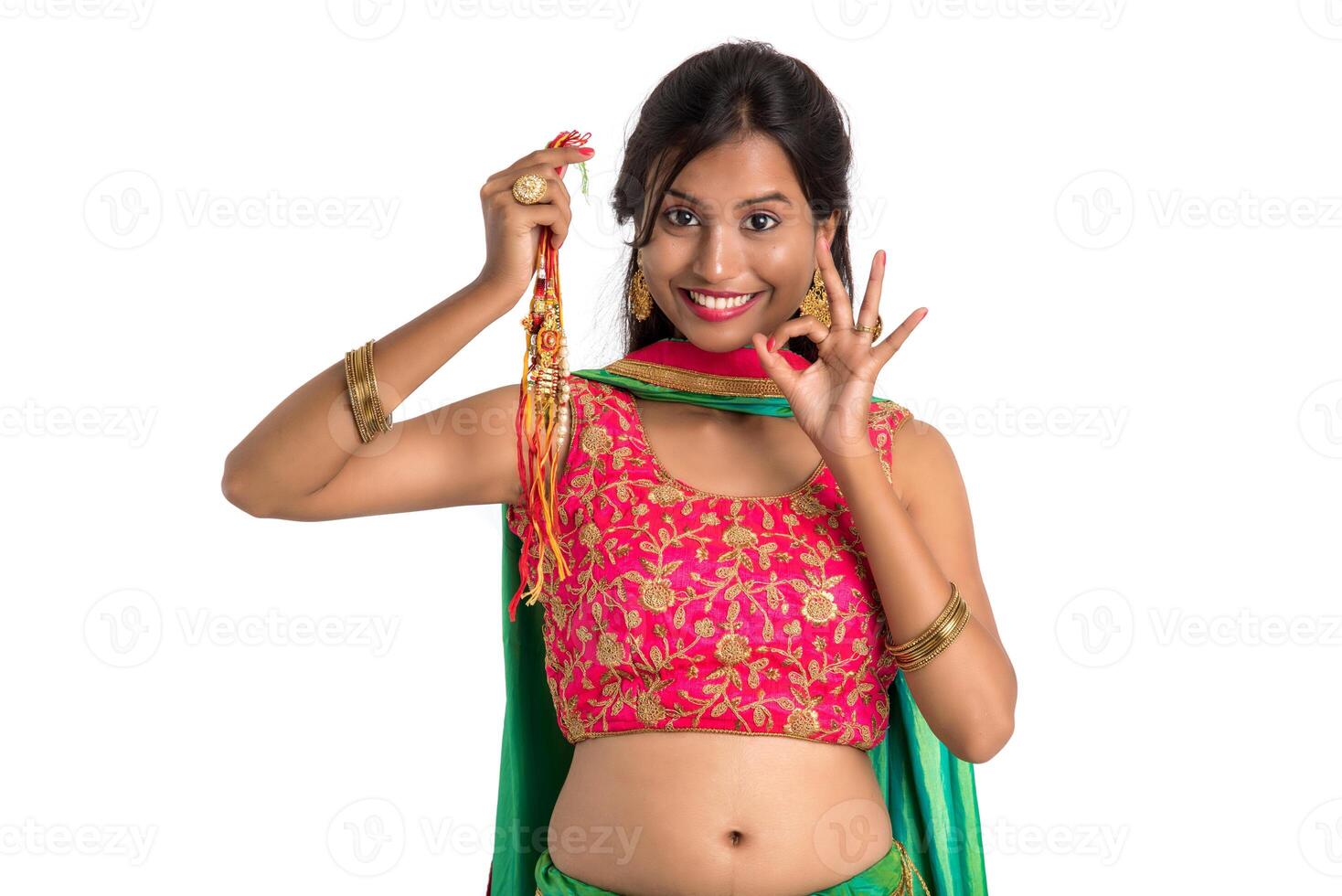 Beautiful girl showing Rakhi on occasion of Raksha bandhan on a white background. Sister tie Rakhi as symbol of intense love for her brother. photo